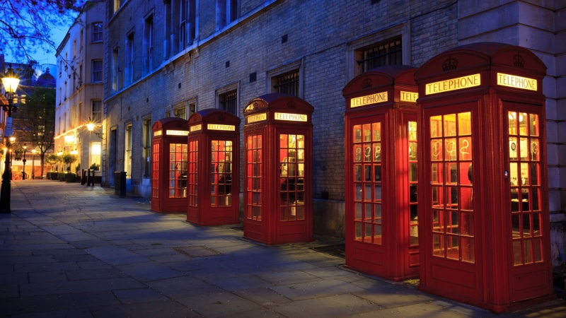 booths, building, architecture, red, city, sidewalk, outdoors, building exterior, built structure, window, night, lighting equipment, direction, dusk, illuminated