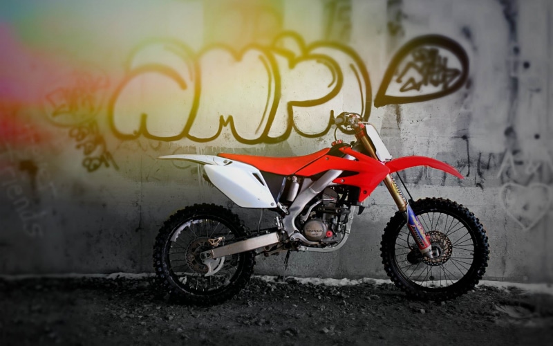 crf, outdoors, graffiti, motocross, communication, motorcycle, dirtbike, bike, architecture, text, white, city, built structure, land vehicle, western script