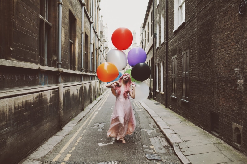 barefoot, full length, red lipstick, day, one person, child, real people, lifestyles, multi colored, pink dress, outdoors, holding, built structure, pink hair