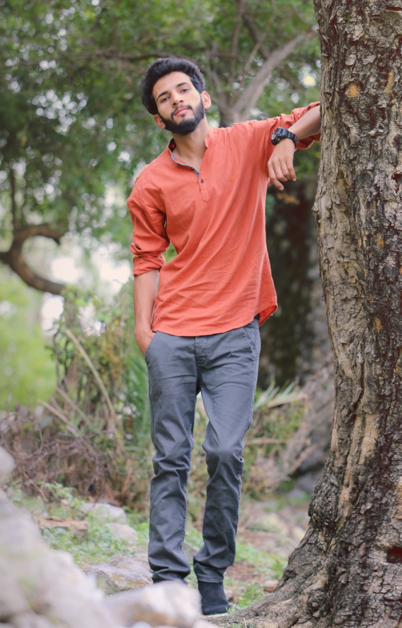 hair style, look, outdoors, day, leisure activity, 5K, trunk, tree trunk, boys fashion, land, tree, male model, one person, forest, shoes, front view
