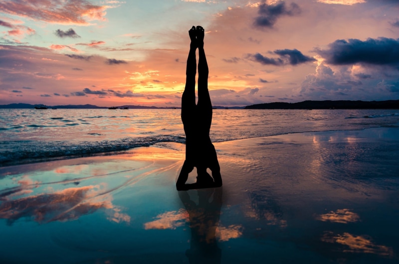 fit, arms raised, relaxation, real people, horizon over water, lifestyles, water, sky, harmony, tranquil scene, reflection, pose, orange color, silhouette