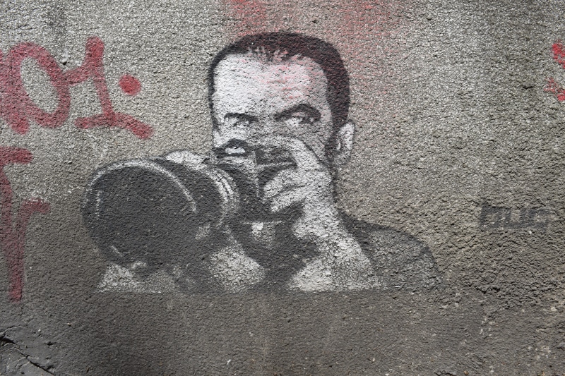 textured, paparazzi, day, street art, camera, drawing - art product, built structure, holding, concrete, paint, 5K, spray paint, art and craft, dirty