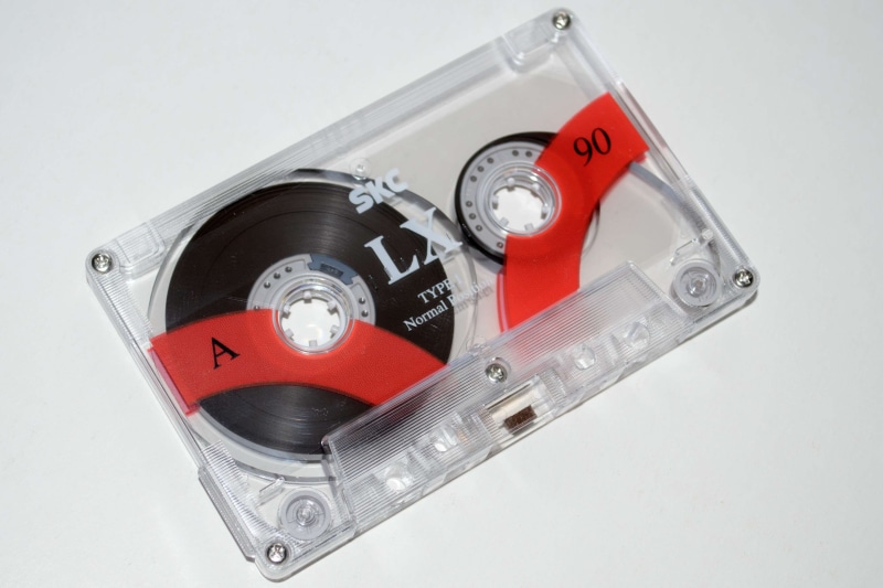 indoors, machinery, white background, single object, tape, music, equipment, sound, still life, man made object, red, record, magnetic tape, silver colored