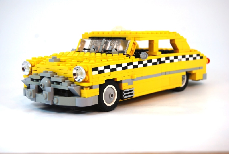 communication, wheel, checkered, transportation, toy, indoors, mode of transportation, LEGO, construction industry, taxi, single object, yellow, truck