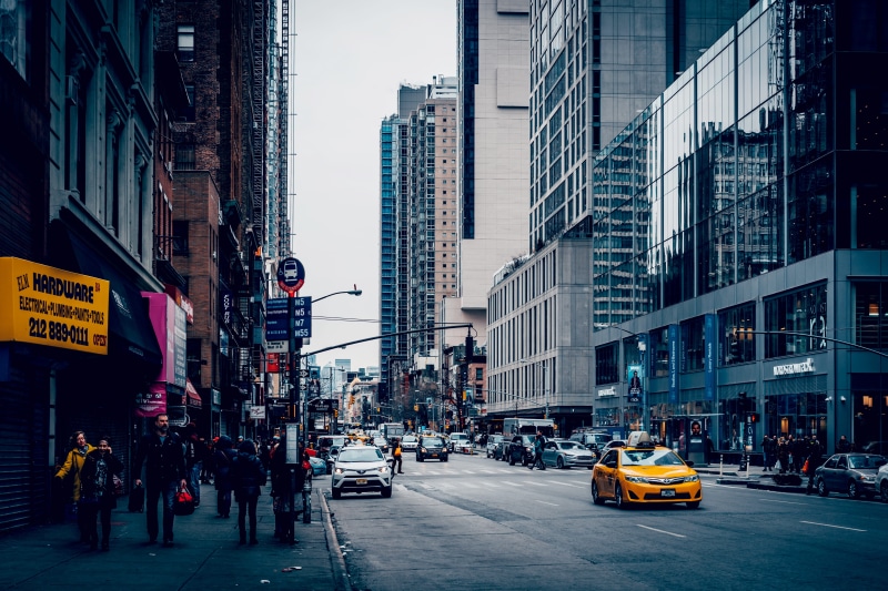 building, taxi, motor vehicle, text, tall - high, city street, yellow, transportation, street, modern, 5K, sign, car, office building exterior, mode of transportation
