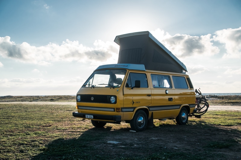 land vehicle, field, motorhome, bike, travel, no people, cloud - sky, land, sunlight, stationary, mode of transportation, grass, combi, nature, road, campervan
