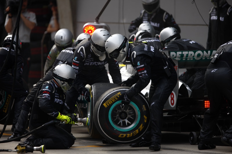 standing, car, government, mode of transportation, motorcycle, uniform, transportation, Formula 1, incidental people, tires, full, face, safety, lot, outdoors
