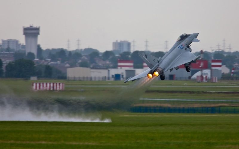 building exterior, no people, air vehicle, outdoors, Eurofighter Typhoon, white, green color, plane, city, day, flying, 1080P, motion, mode of transportation