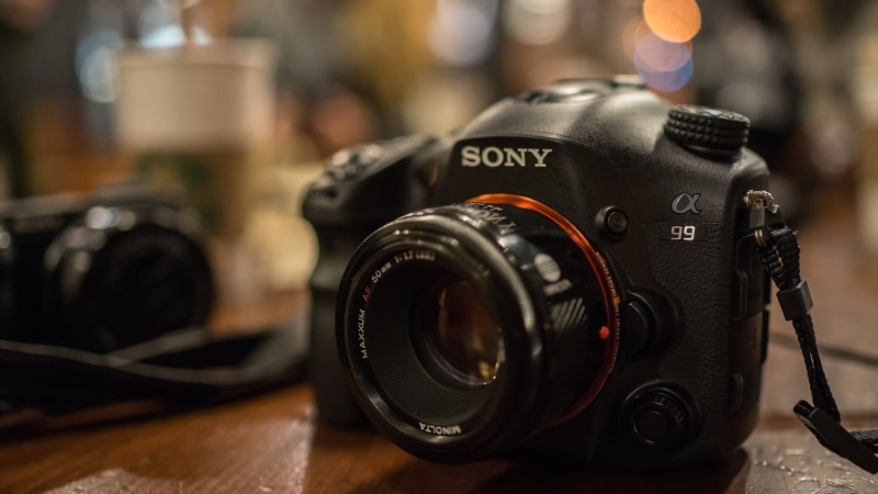 Sony, still life, indoors, camera, single object, photographing, no people, technology, 1080P, text, camera - photographic equipment, depth of field, focus on foreground