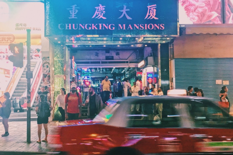 text, motion, outdoors, illuminated, streets, blurred motion, crowd, taxi, architecture, group of people, traffic, city life, transportation, mode of transportation