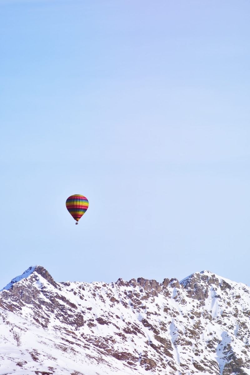 sky, snowcapped mountain, air vehicle, winter, clear sky, no people, mountain peak, mid-air, covered, hot air balloon, flying, extreme sports, beauty in nature