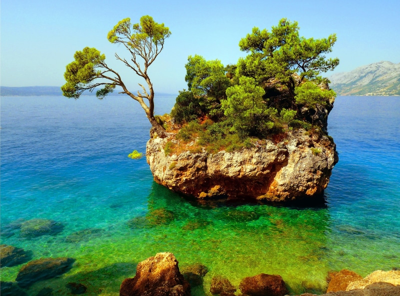 growth, turquoise colored, tranquility, rock, outdoors, green, sky, beauty in nature, solid, plant, trees, nature, idyllic, water, tree, leafed, rock - object