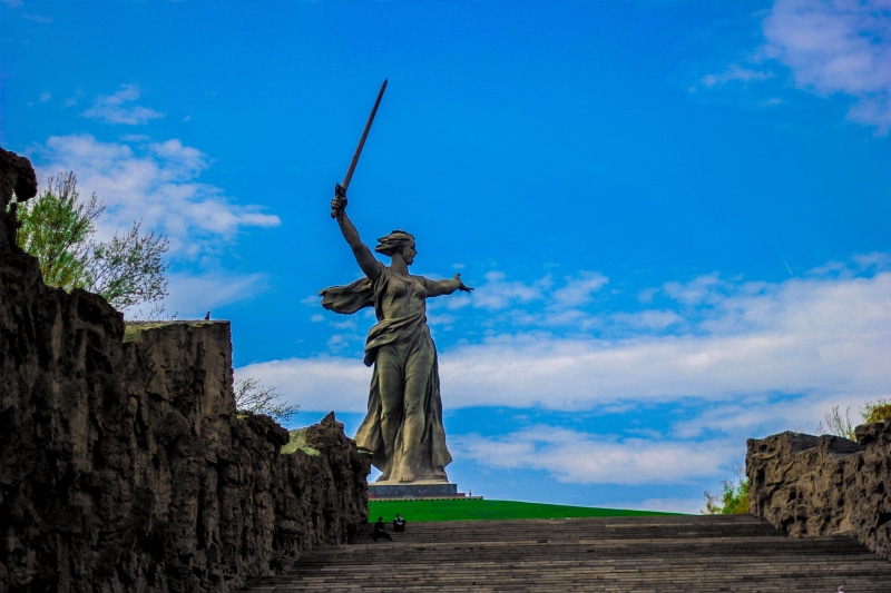 female likeness, history, representation, daylight, angel, male likeness, arms raised, the past, sky, blue, outdoors, art and craft, low angle view, memorial