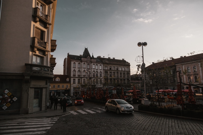 urban photography, cloud - sky, building, car, city street, moody, transportation, sky, street light, urban, wide, architecture, road, outdoors, mode of transportation