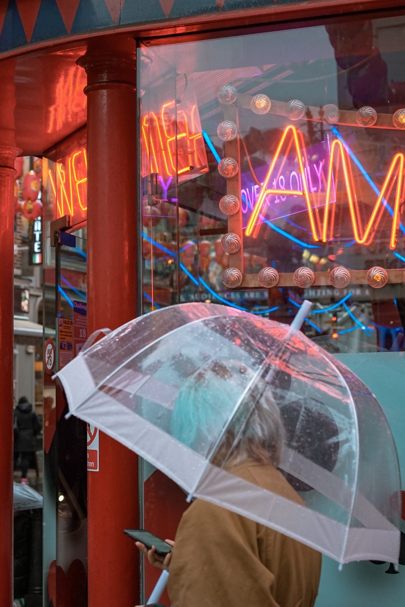 arts culture and entertainment, white, city, architecture, adult, black, front, shop, umbrella, neon, glass - material, women, store, text, blue hair, night