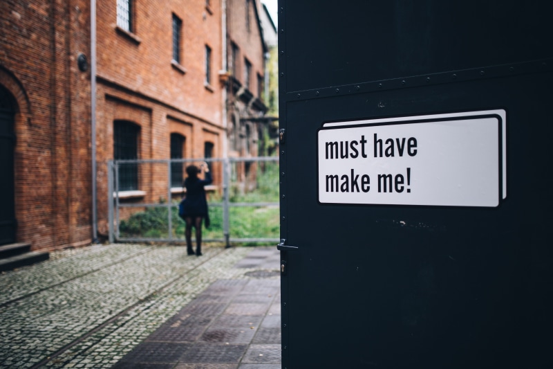 pavement, people, building, information, brick, doors, entrance, gallery, day, bucket, street, sign, western script, footpath, one person, guidance, 5K