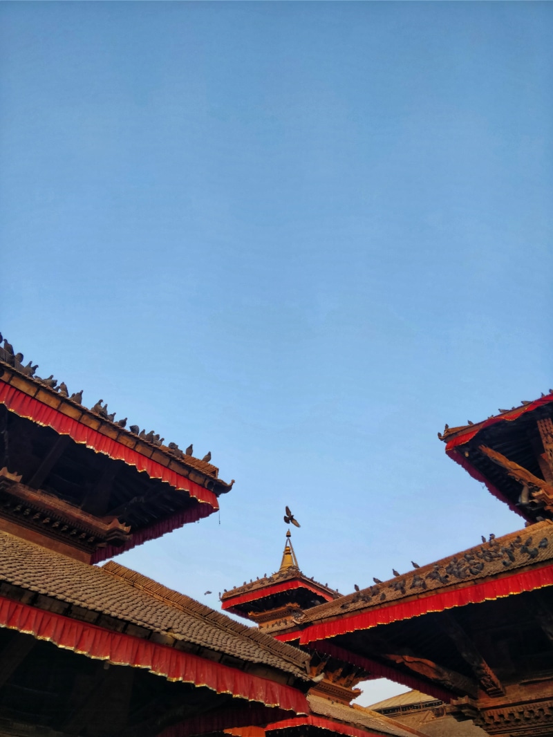 no people, nature, travel destinations, sky, eaves, belief, clear sky, place of worship, low angle view, architecture, building, day, heritage, roof, nepal