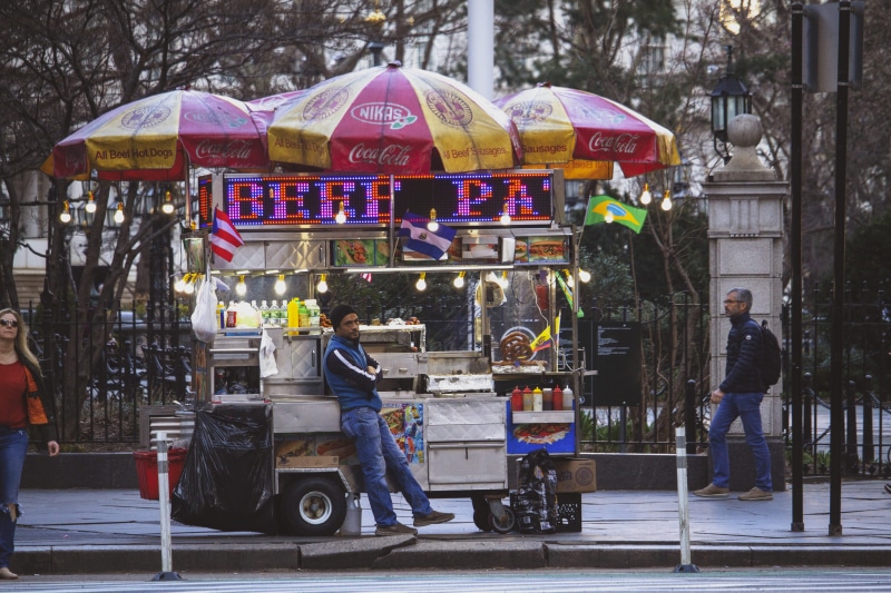 outdoors, kiosk, architecture, shoe, 5K, transportation, full length, city, pants, shop, real people, street, group of people, person, wheel, incidental people