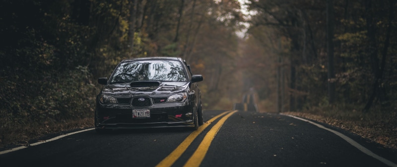 outdoors, tree, forest, sign, day, ultra wide car subaru impreza rally, car, road marking, 2K, land vehicle, mode of transportation, land, symbol, no people