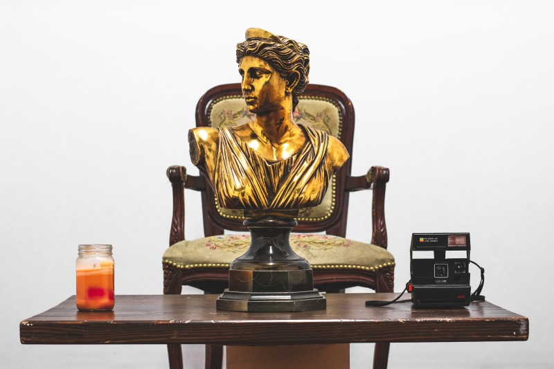 old, vintage camera, vintage, furniture, art and craft, room, table, facial expression, sculpture, religion, container, metal, seat, candle, veil, gold colored
