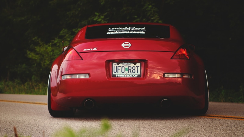 road, tree, sports car, mode of transportation, number, day, land vehicle, transportation, Nissan, car, sunlight, red, retro styled, Nissan 350Z, motor vehicle