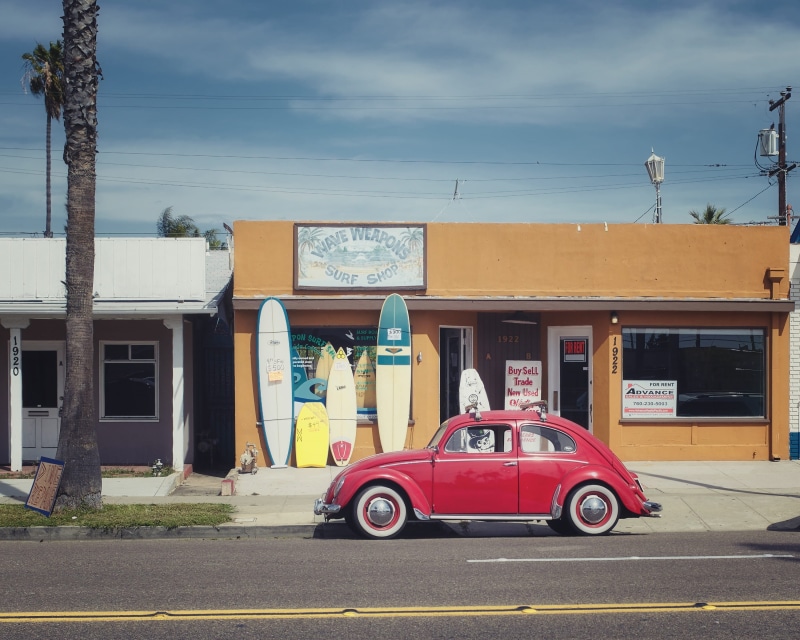surfboards, road, transportation, style, land vehicle, near, oldtimer, building exterior, architecture, real people, city, classic car, men, shop, daytime