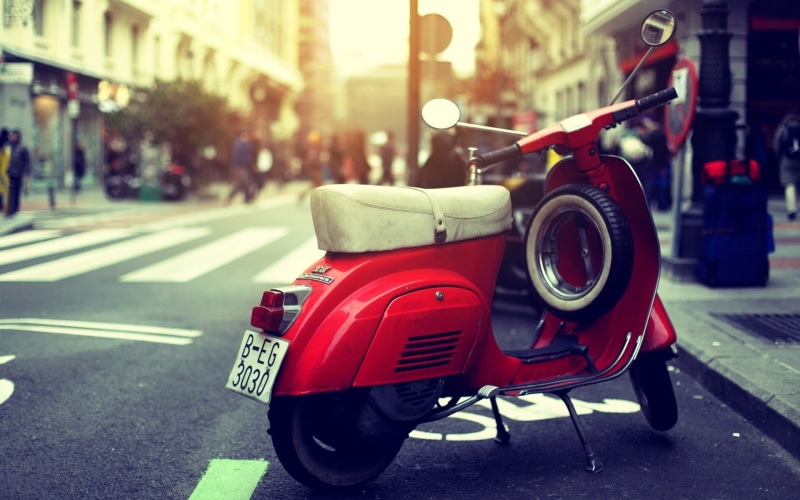 architecture, outdoors, parked, wheel, city street, 1080P, building exterior, day, street, land vehicle, lane, mode of transportation, bike, scooter, stationary