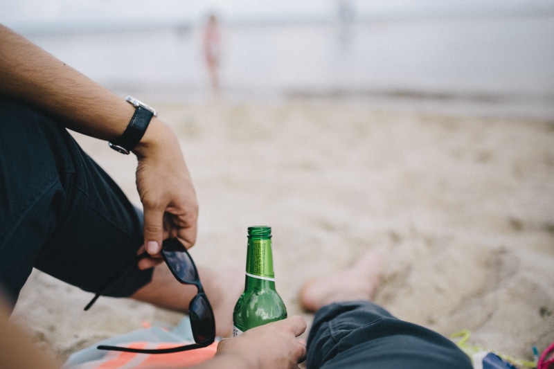 beer, sand, bottle, human body part, container, beer - alcohol, people, drinking, men, land, focus on foreground, day, together, holding, beach, caucasian Ethnicity