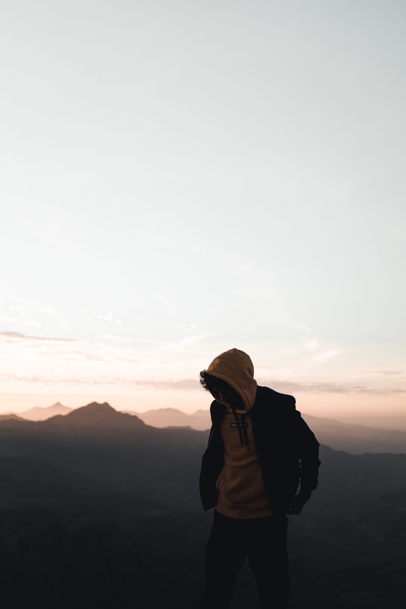 hoodie, bag, leisure activity, mountain, standing, man, rear view, sky, three quarter length, copy space, sweater, scenics - nature, beauty in nature, lifestyles
