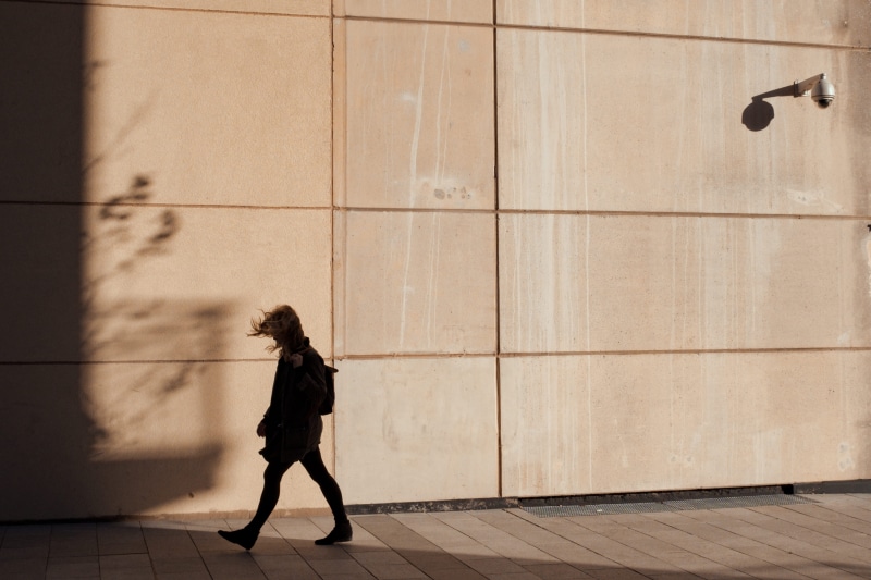 windy, 4K, women, sunlight, walk, wall, day, footpath, flooring, motion, city, on the move, beside, wall - building feature, apparel, outdoors, building exterior