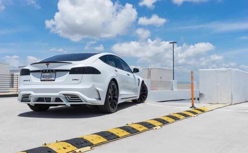 road marking, motor vehicle, wheel, tesla model s, yellow, 2K, industry, no people, back view, transportation, sky, text, communication, mode of transportation