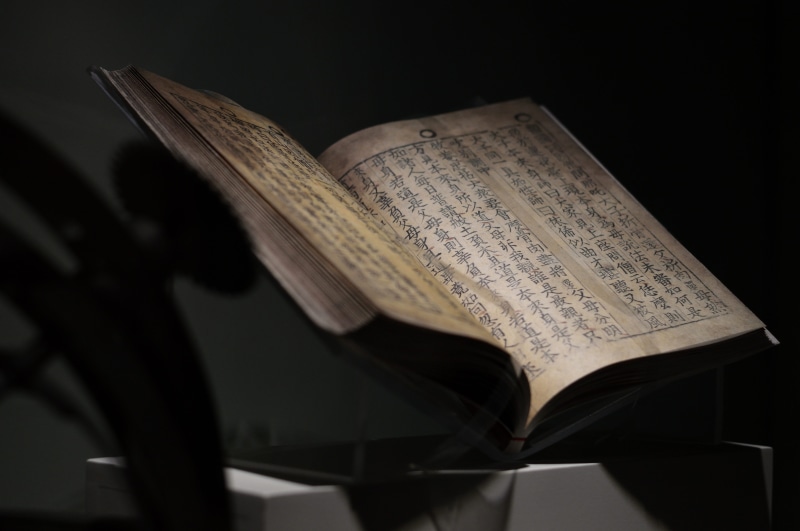 close-up, paper, indoors, old book, studio shot, spirituality, page, handmade, open, ink, aged, knowledge, old, black background, still life, chinese, religion