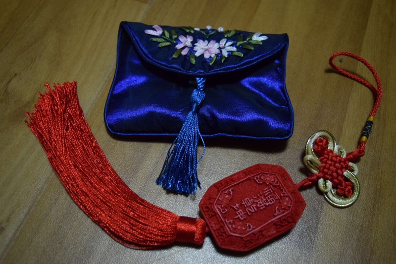 red, representation, indoors, flowering plant, pouch, gift, table, no people, jewelry, decoration, traditional, purple, writing, still life, textile, china