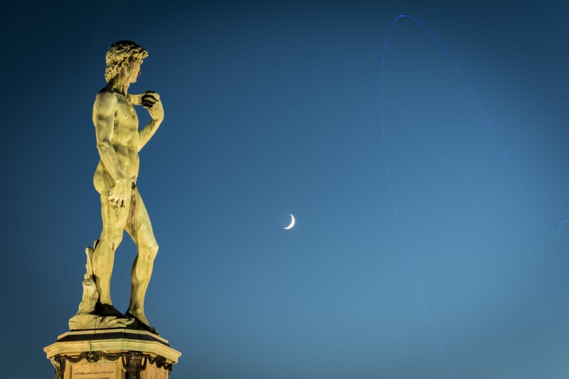 no people, female likeness, representation, art and craft, sculpture, italian, tourism, low angle view, blue background, david, angel, male likeness, statue