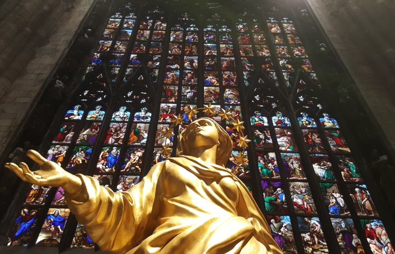 religion, place of worship, woman, madonnina, wall, urban, outdoor, built structure, duomo, human arm, church, artistic, creativity, sculpture, milan, glass