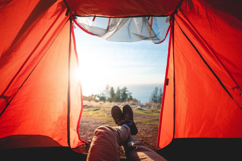 lying, sunlight, camping, people, mountain tent, 5K, feet, rural, casual clothing, real people, day, orange color, textile, men, leisure activities, relaxation