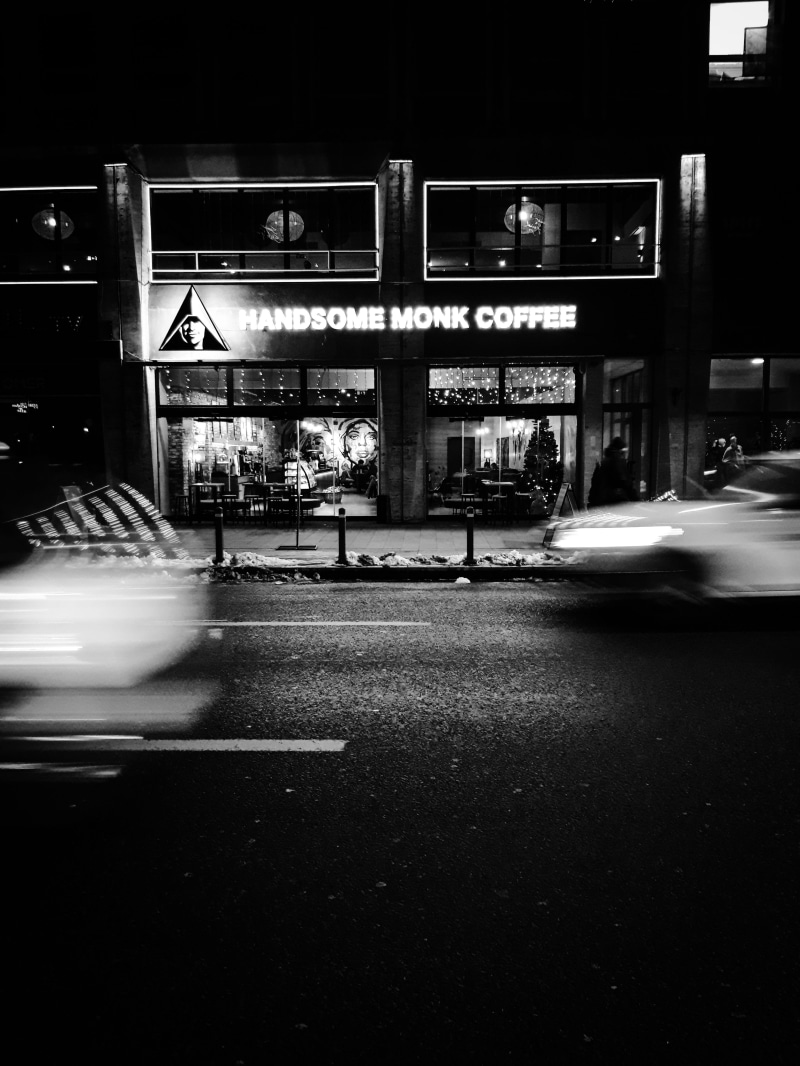 blurred motion, nightlife, motor vehicle, illuminated, dark, restaurant, car, mode of transportation, signage, text, communication, coffee shop, storefront