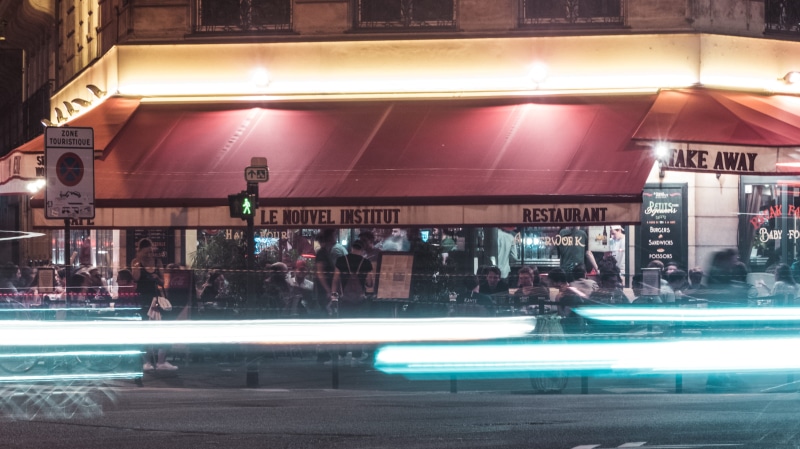 electronics, street, built structure, women, diner, building exterior, indoors, motion, cafe, city, group of people, lighting, crowd, city life, incidental people