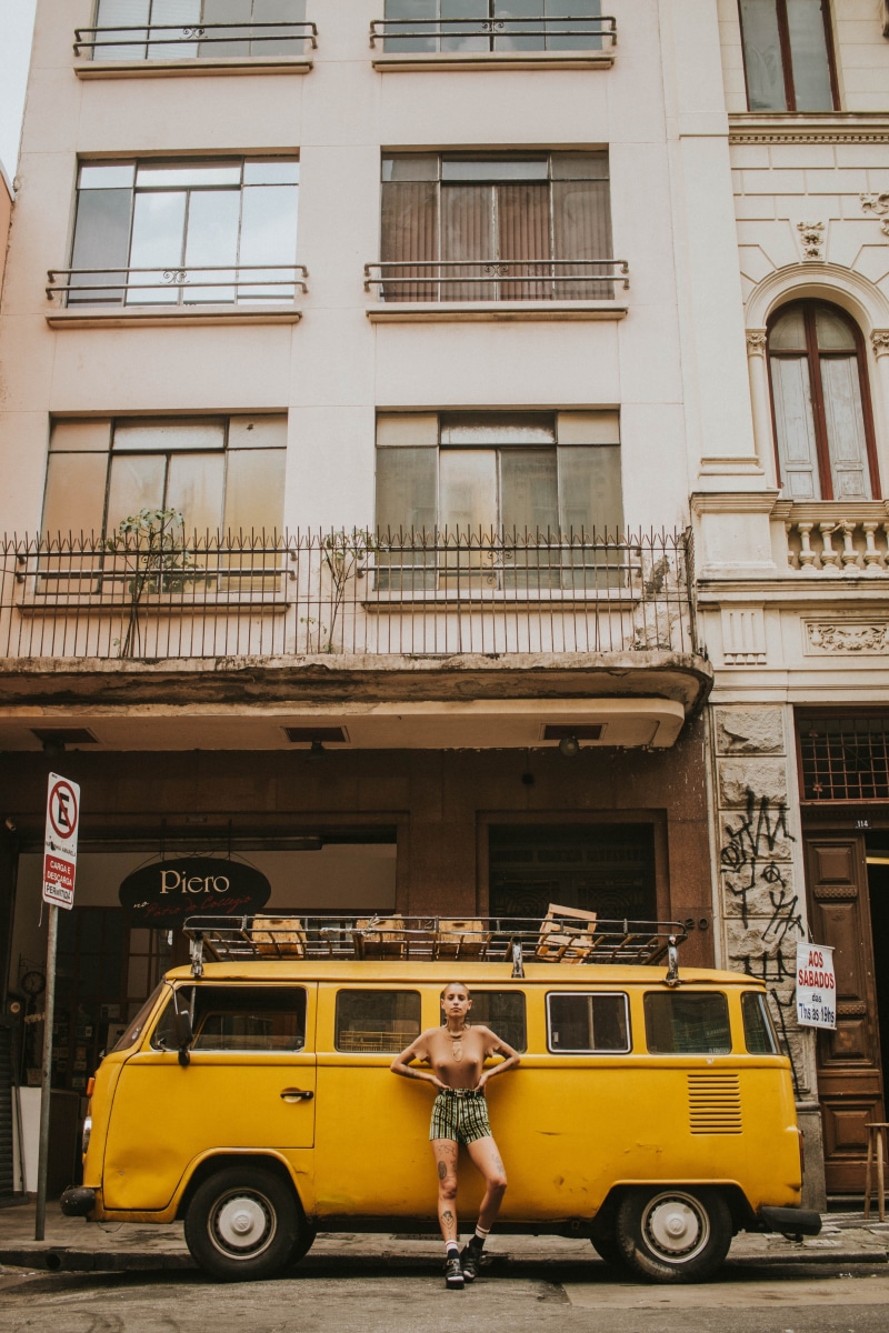 building, city life, yellow, building exterior, young adult, outdoors, day, vehicle, street, daytime, town, motor vehicle, car, leaning, architecture, city