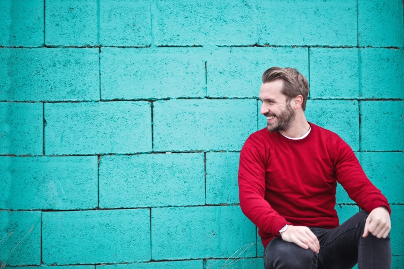male, Smiling, beard, young men, young adult, man, Sitting, modern, red sweater, sit, sweater, 30-35 years old, wearing, caucasian, black pants, outdoor