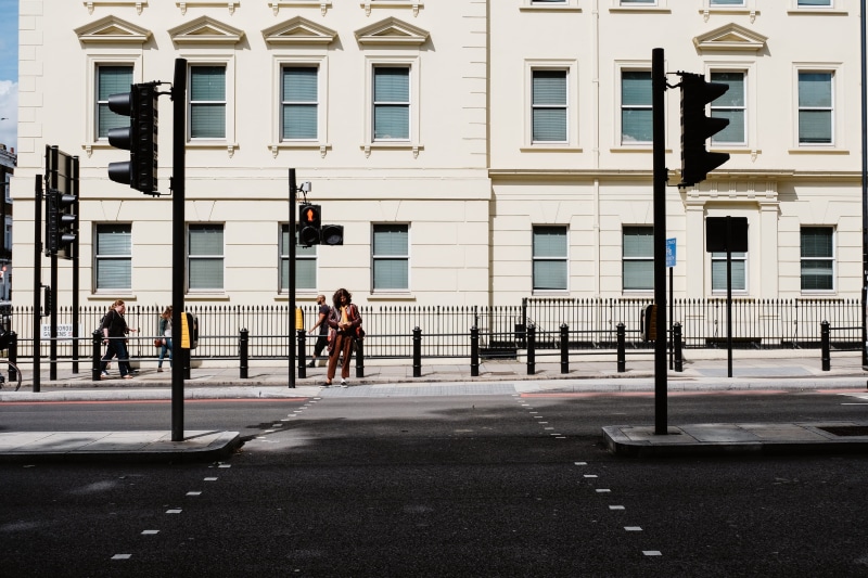 crossing, concrete, women, transportation, city life, men, road, standing, sunlight, man, people, real people, built structure, street, day, building exterior