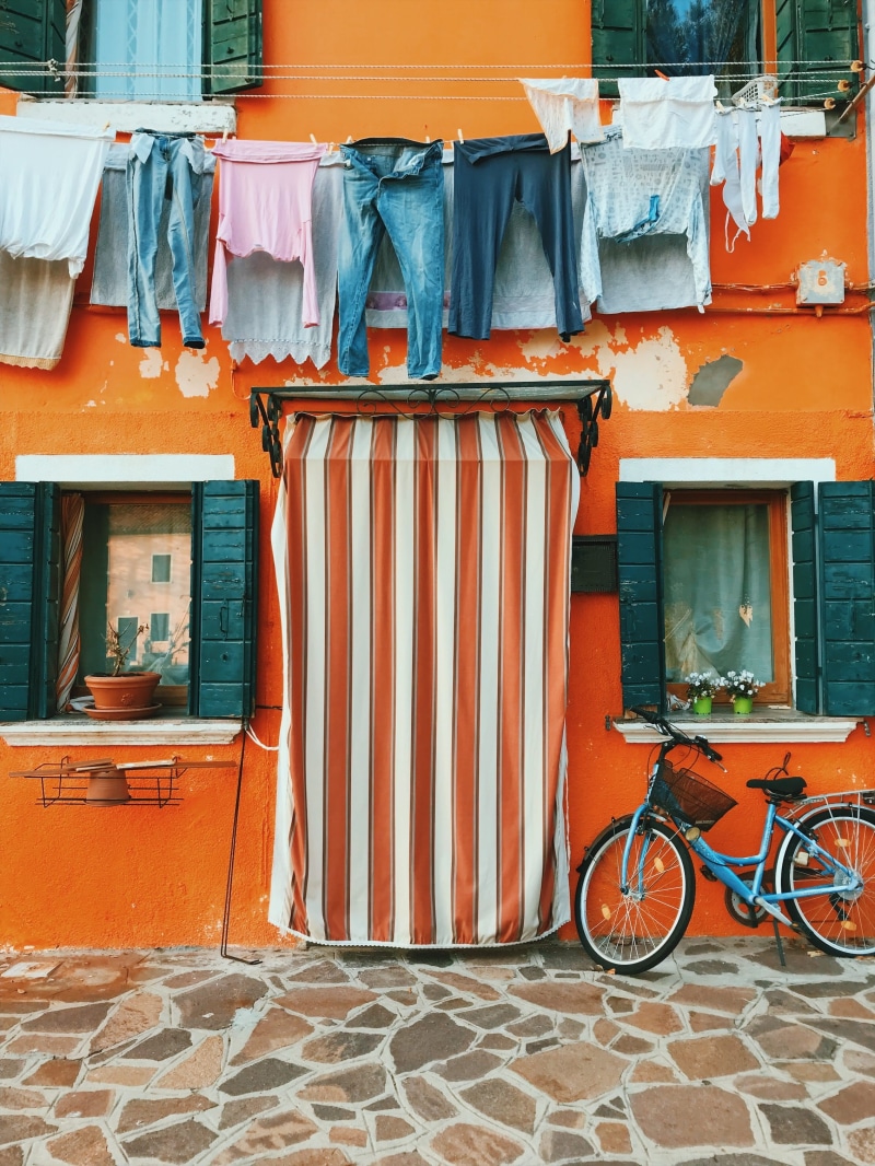 cover, wall - building feature, parked, bike, house, doorway, orange, entrance, white, city, day, outdoors, bicycle, door, colour, dwelling, near, architecture