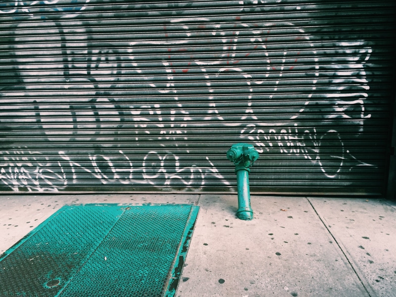 one person, garage, outdoors, graffiti, nature, hydrant, footpath, door, wall, near, casual clothing, urban, metal, architecture, 2K, standing, green color