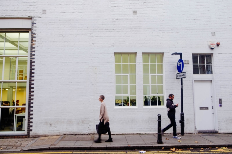 full length, brick, white, outdoors, real people, 4K, women, sign, leisure activity, males, brick wall, sidewalk, street, standing, walk, fashion, casual clothing