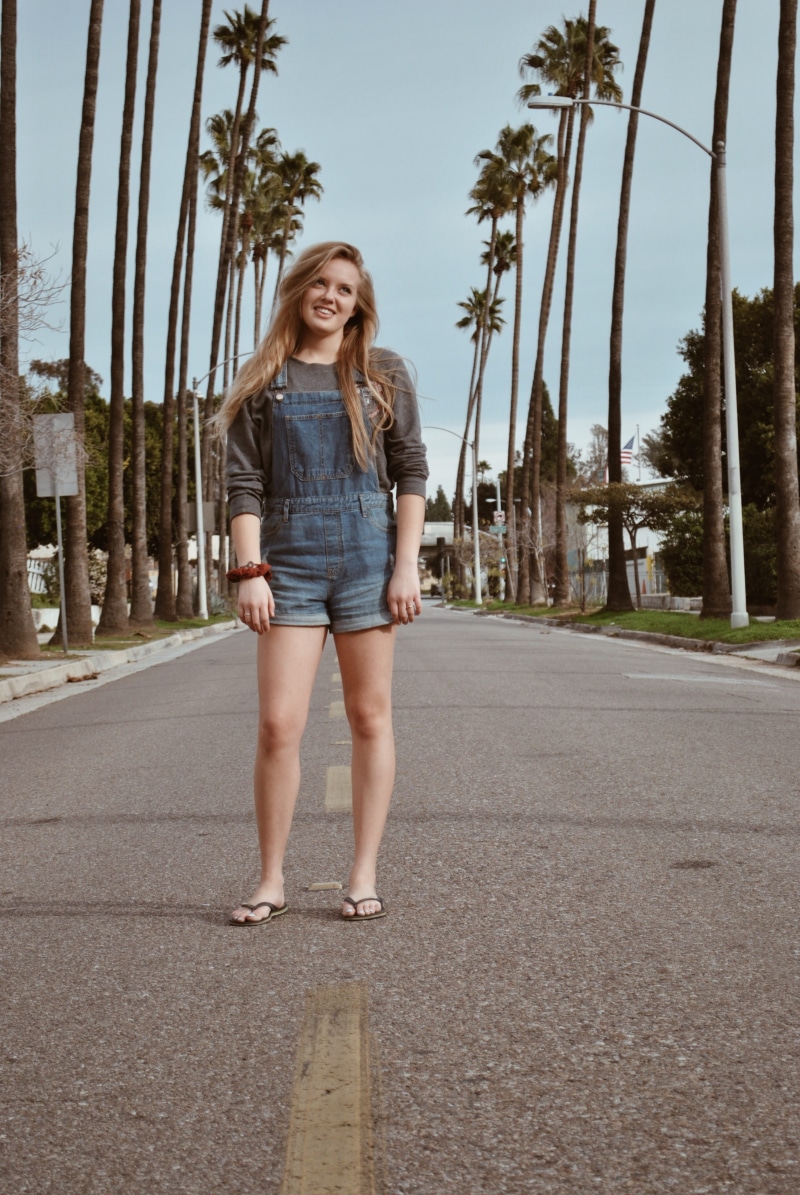 portrait, transportation, plant, person, road, pants, clothing, palm tree, jacket, lifestyles, shorts, long sleeve, hairstyle, looking at camera, full length