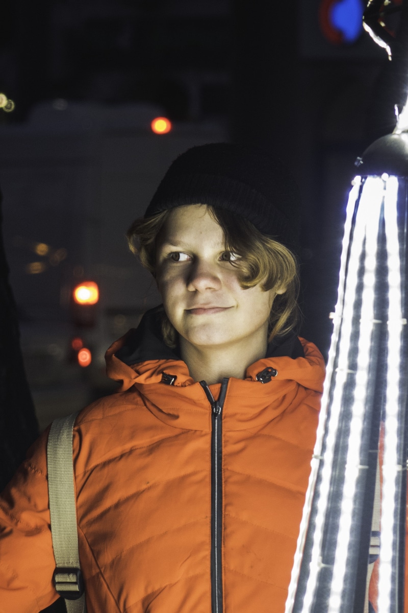 real people, hat, fireman, lifestyles, 4K, coat, person, night, hood, clothing, man, jacket, teen, young men, lights, looking at camera, focus on foreground