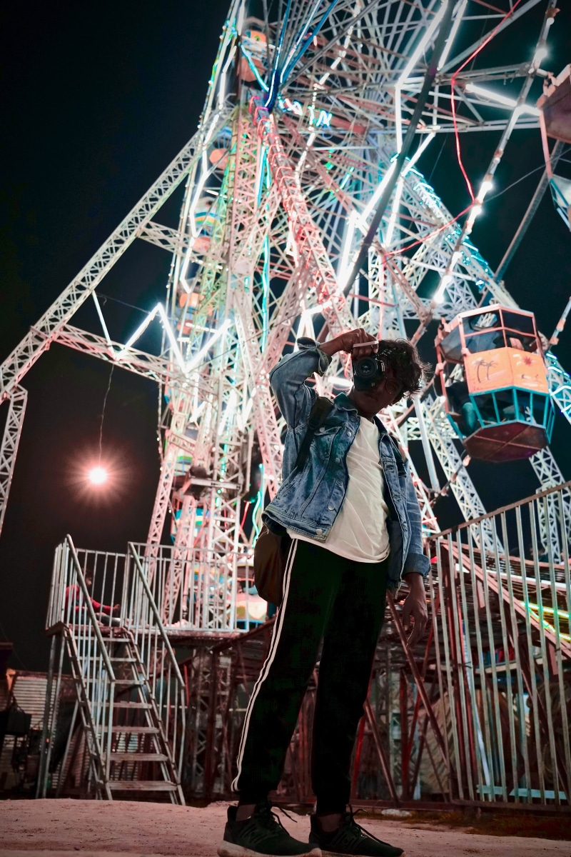 alloy wheel, theme park, wheel, amusement park ride, human, arts culture and entertainment, adventure, sky, spoke, clothing, night, plywood, leisure activity