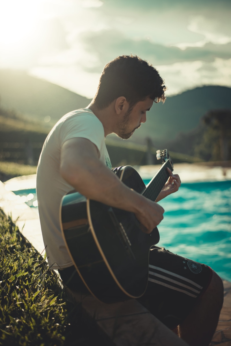 blur, outdoors, guitar, stringed instrument, water, nature, recreation, 5K, young men, wear, model, side view, casual clothing, lifestyles, real people