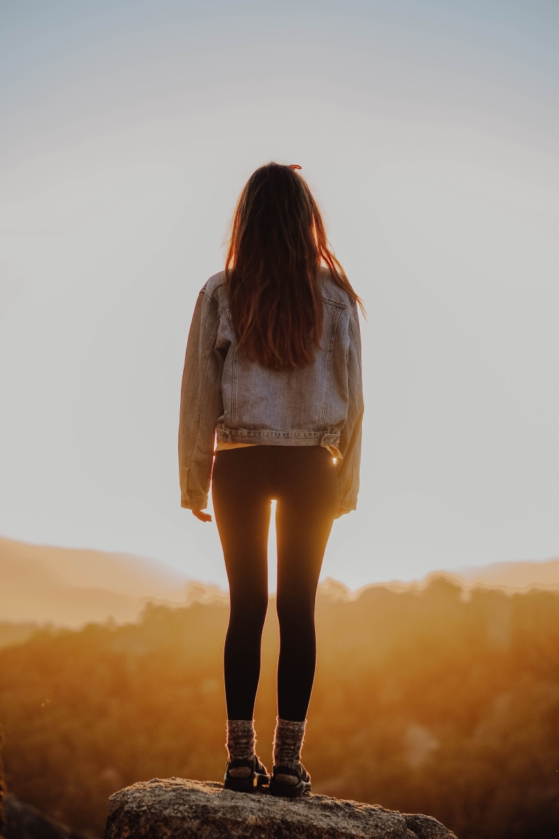 lifestyles, looking at view, leisure activity, sunlight, one person, wanderlust, hour, sunset, denim, adult, nature, yellow, walk, legs, black, from behind