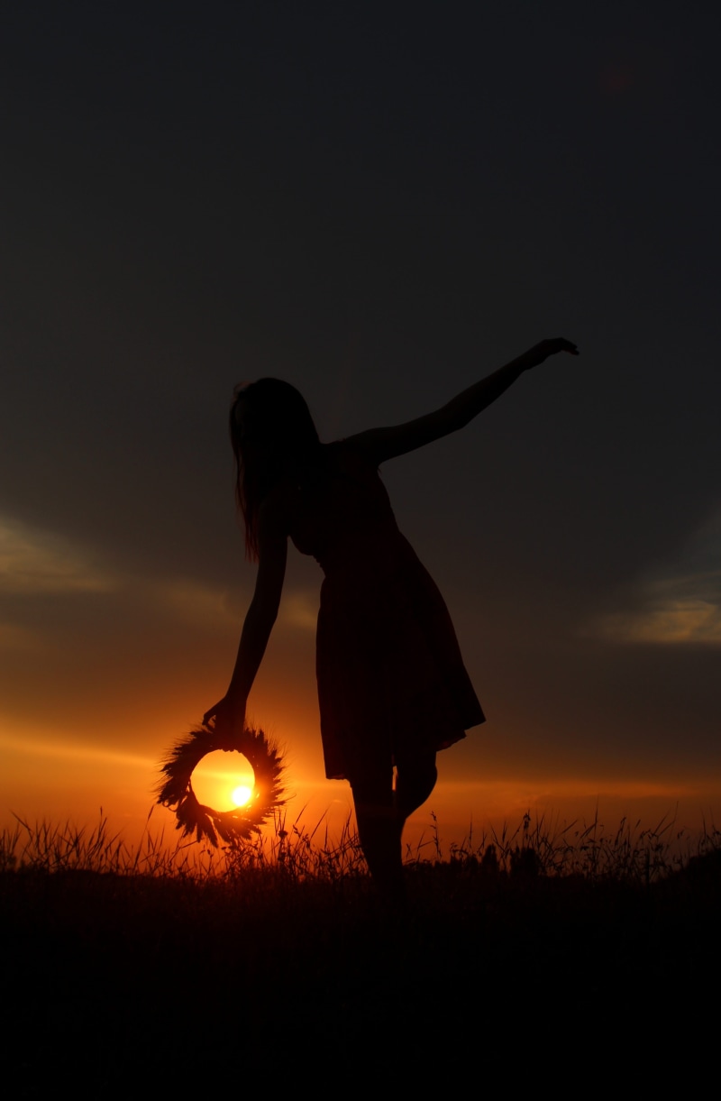 one Person, outdoors, plant, only women, twilight, human arm, females, arms raised, people, nature, sunset, wreath, sky, leisure activity, standing, orange color